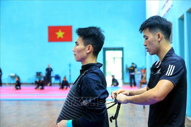Trong ảnh: Các vận động viên đeo áo giáp trước khi tập luyện. Ảnh: Tuấn Anh - TTXVN