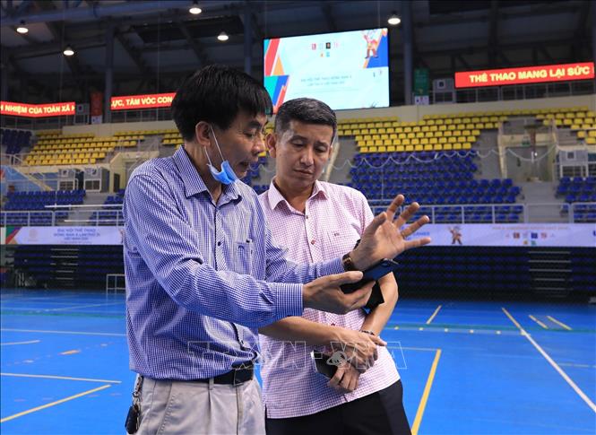 Phó Tổng cục trưởng Tổng cục TDTT Nguyễn Danh Hoàng Việt nghe báo cáo về công tác chuẩn bị của Nhà thi đấu đa năng tỉnh Quảng Ninh quy mô 5000 chỗ ngồi ở phường Đại Yên, thành phố Hạ Long - nơi diễn ra các nội dung thi đấu môn bóng chuyền trong nhà. Ảnh: Hoàng Hiếu - TTXVN 