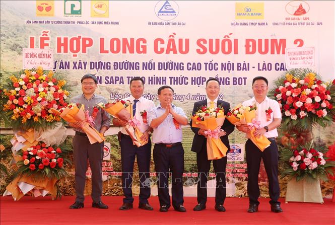 Trong ảnh: Đại diện tỉnh Lào Cai tặng hoa chúc mừng các đơn vị thi công cầu Suối Đum 2. Ảnh: Quốc Khánh - TTXVN