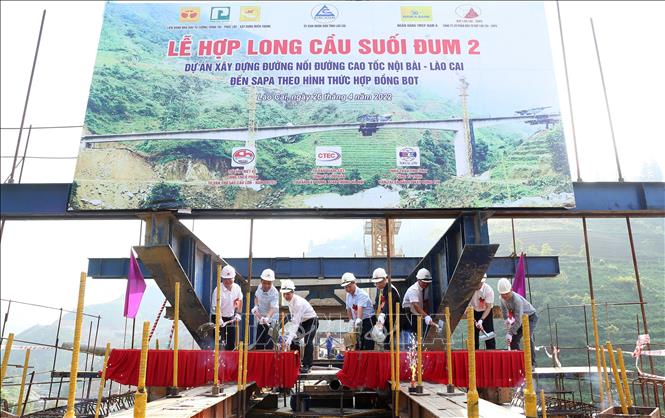 Trong ảnh: Các đại biểu thực hiện nghi thức hợp long cầu Suối Đum 2. Ảnh: Quốc Khánh - TTXVN