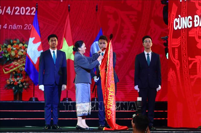 Trong ảnh: Phó Chủ tịch nước Lào Pany Yathotou gắn Huân chương Phát triển hạng Nhì của Nhà nước CHDCND Lào lên lá cờ truyền thống của Ngân hàng BIDV. Ảnh: An Đăng - TTXVN
