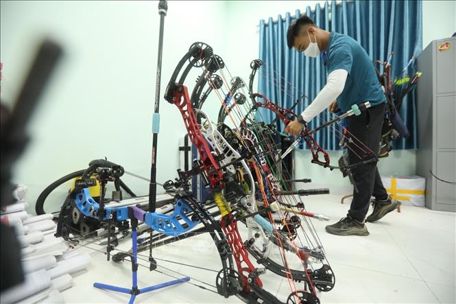 Photo: Archer Nguyen Minh Quy selects a compound bow for practice. VNA Photo: Minh Quyết
