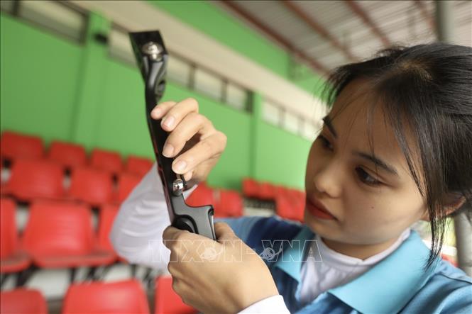 Photo: Archer Do Thi Anh Nguyen prepares her bow carefully before practicing. VNA Photo: Minh Quyết