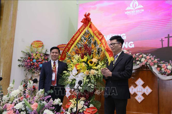 Photo: Nguyen Tien Trong (R), Vice Chairman of the Government Committee for Religious Affairs presents greeting flowers to the Evangelical Church of Vietnam (North). VNA Photo: Công Luật