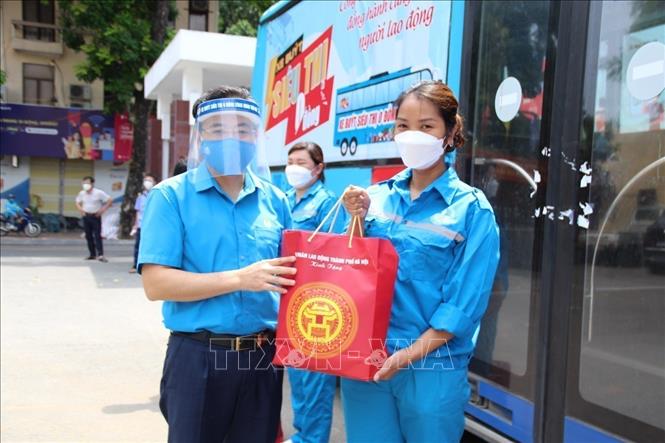 Công nhân Công ty TNHH Một thành viên Nước sạch Hà Đông nhận quà hỗ trợ từ lãnh đạo tổ chức Công đoàn Thủ đô. Ảnh: TTXVN phát