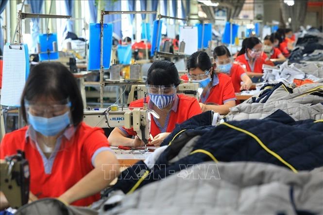 Công nhân Công ty CP may Chiến Thắng đảm bảo công tác phòng, chống dịch COVID-19 trong sản xuất. Ảnh: Tuấn Anh - TTXVN