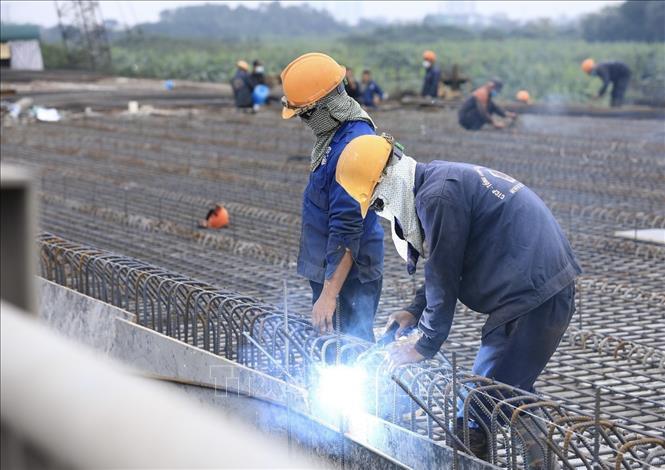 Nhiều công nhân đón Tết Dương lịch 2022 ngay trên công trường Cầu Vĩnh Tuy 2 để đẩy nhanh tiến độ, đảm bảo chất lượng công trình. Ảnh: Hoàng Hiếu - TTXVN
