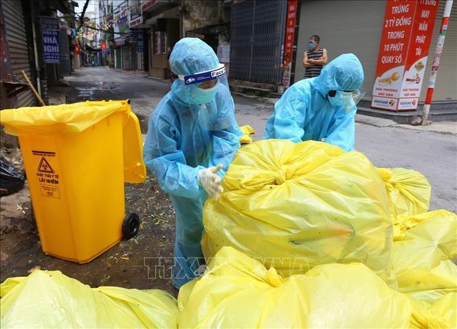 Nhằm đảm bảo phòng, chống COVID-19, giữ gìn vệ sinh môi trường trong khu vực phong tỏa, đội ngũ công nhân vệ sinh môi trường Thủ đô tình nguyện vào bên trong các khu cách ly, có mặt tại khắp ngõ, ngách nguy cơ cao với nhiệm vụ dọn dẹp rác thải hằng ngày được coi là chất thải lây nhiễm. Ảnh: Hoàng Hiếu - TTXVN