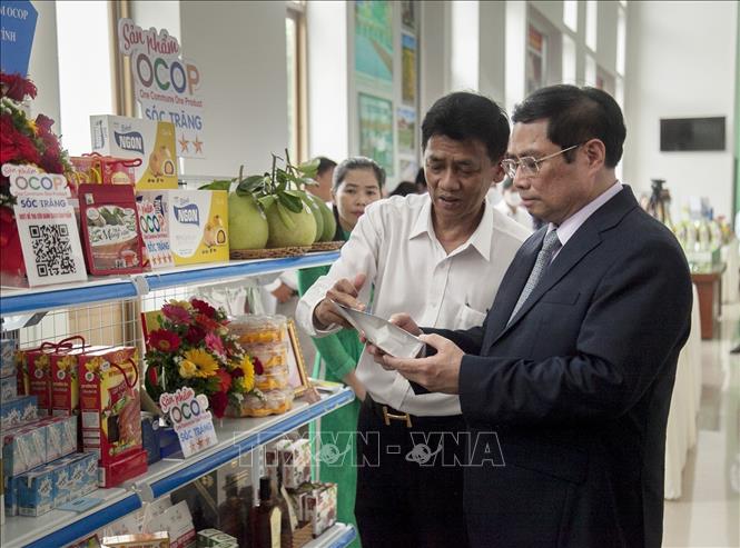 Trong ảnh: Thủ tướng Chính phủ Phạm Minh Chính nghe Bí thư Tỉnh ủy Sóc Trăng Lâm Văn Mẫn giới thiệu các sản phẩm OCOP của tỉnh Sóc Trăng. Ảnh: Hồng Đạt - TTXVN

