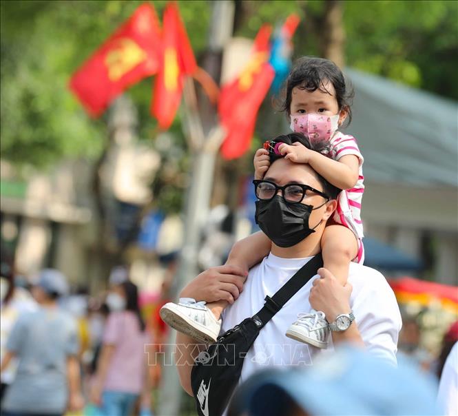 Em nhỏ được đi chơi phố đi bộ. Ảnh: Thanh Tùng -TTXVN 