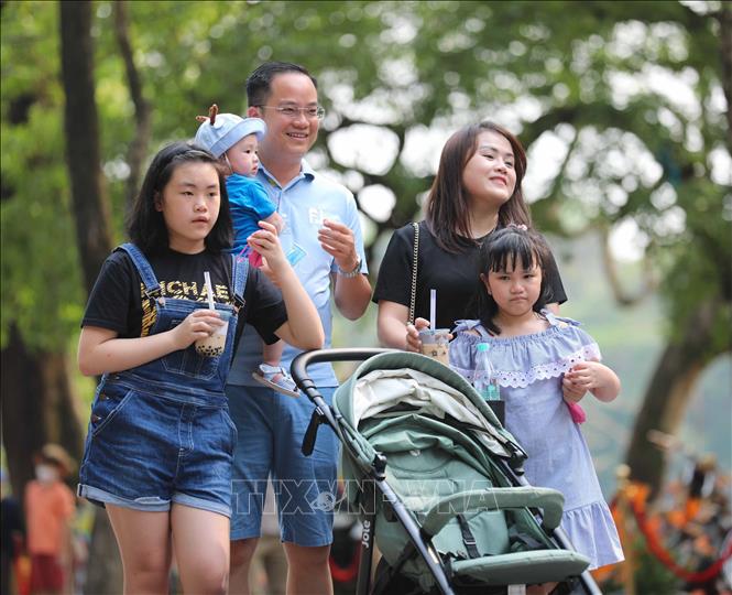 Một gia đình hòa mình cùng không khí sôi động trên phố đi bộ. Ảnh: Thanh Tùng - TTXVN