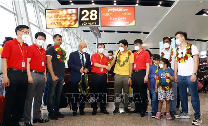 Photo: The flight's first passengers pose for a photo with officials from the Civil Aviation Authority and Vietjet. VNA Photo: Huy Hùng