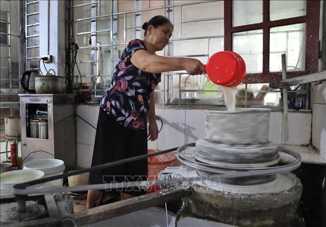 Gạo ngon được đem ngâm nước rồi xay nhuyễn để tạo thành thứ bột nhỏ mịn và trắng muốt để tráng bánh. Ảnh: Danh Lam-TTXVN
