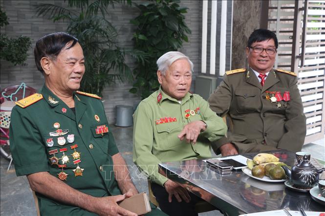 Trong ảnh: Cựu chiến binh Trần Xuân Kình (giữa) cùng đồng đội lính Trường Sơn kể những câu chuyện về trung đoàn pháo cao xạ 367 chiến đấu tại chiến trường Điện Biên Phủ. Ảnh: Bích Huệ - TTXVN