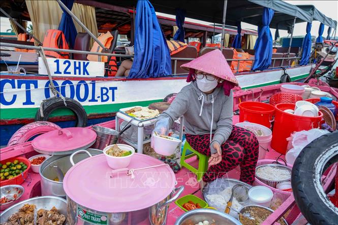 Trong ảnh: Bà chủ chiếc ghe hồng chuẩn bị các phần bún riêu phục vụ du khách. Ảnh: Thanh Liêm - TTXVN