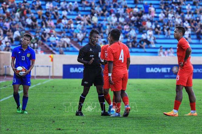 Trọng tài nhắc nhở các cầu thủ U23 Singapore sau pha phạm lỗi với cầu thủ U23 Lào. Ảnh: Tuấn Anh - TTXVN