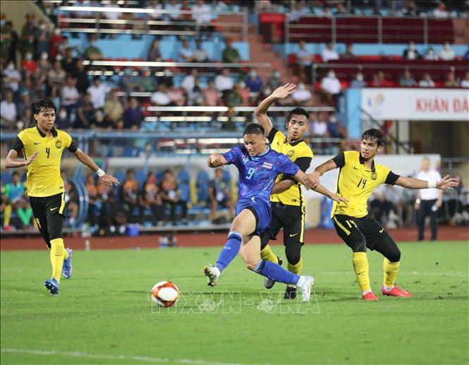 Thai player dribbles the ball past his opponents. VNA Photo 