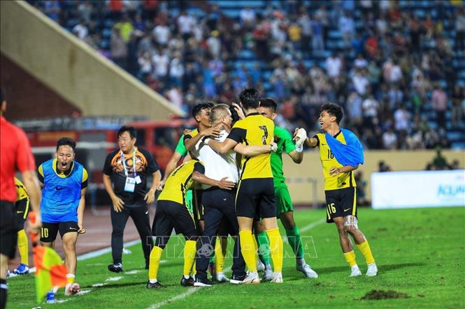 Head coach Bradley John Maloney and Malaysian U23 players cheer together after winning the match. VNA Photo