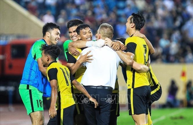 Head coach Bradley John Maloney and Malaysian U23 players cheer together after winning the match. VNA Photo