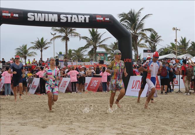 Trong ảnh: Các vận động viên xuất phát tranh tài phần thi bơi 1,9 km trên biển. Ảnh: Trần Lê Lâm - TTXVN 
