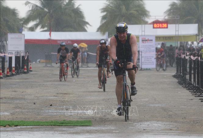 Trong ảnh: Các vận động viên tranh tài đạp xe trong thời tiết mưa lớn. Ảnh: Trần Lê Lâm - TTXVN 