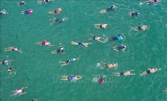 Trong ảnh: Các vận động viên xuất phát tranh tài phần thi bơi 1,9 km trên biển. Ảnh: Trần Lê Lâm - TTXVN 