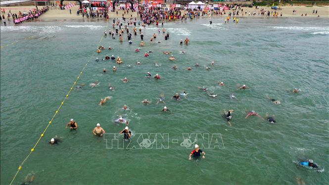 Trong ảnh: Các vận động viên xuất phát tranh tài phần thi bơi 1,9 km trên biển. Ảnh: Trần Lê Lâm - TTXVN 