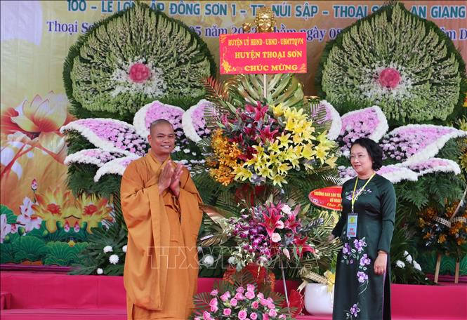 Bà Nguyễn Thị Minh Kiều, Bí thư Huyện ủy Thoại Sơn, tỉnh An Giang tặng lẵng hoa chúc mừng cho đại diện Thiền viện Trúc Lâm An Giang. Ảnh: Công Mạo-TTXVN