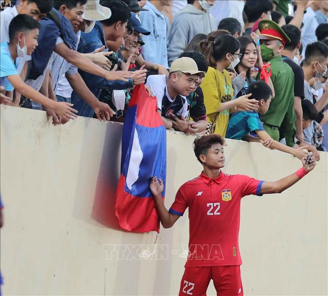 Dù thua trận, tiền vệ U23 Lào Sinnakone (22) vẫn vui vẻ chụp ảnh cùng cổ động viên Việt Nam sau khi kết thúc trận đấu. Ảnh: Thanh Tùng - TTXVN