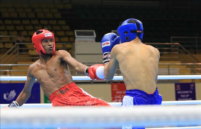 Cambodian kickboxer Chhoeung Lvay (red shorts) wins 3:0 against Singaporean kickboxer Nazri Bin Sutari Muhammad (blue shorts) in the kickboxing low kick competition (under 71kg category). VNA Photo 
