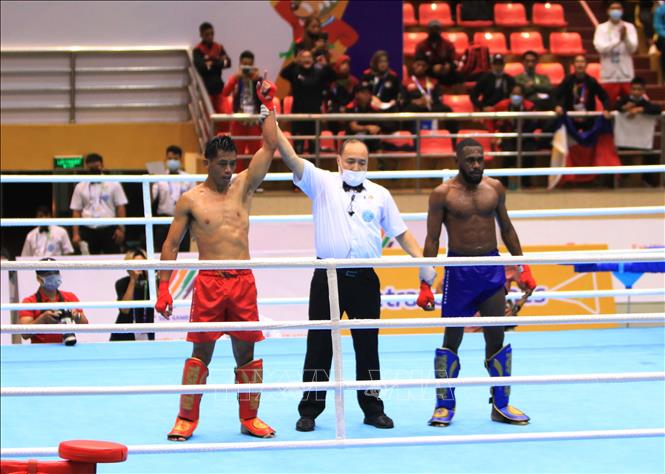 Philippine kickboxer Antonio Honorio (red shorts) wins 3:0 against Indonesian kickboxer Tanoi Yermias_Yohanes in the kickboxing low kick competition (under 71kg category). VNA Photo 