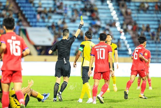 Referee Yahya Ali Mohammad Hassan Almulla gives a yellow card to Lao No.6 player after a foul. VNA Photo: Tuấn Anh 