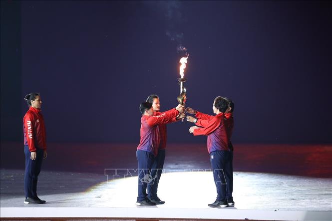 Bộ đôi cựu VĐV Trần Lê Quốc Toàn (cử tạ), Lê Bích Phương (karate) trao lại đuốc cho bộ đôi cựu VĐV Hoàng Anh Tuấn (Cử tạ), Nguyễn Thúy Hiền (Wushu). Ảnh: TTXVN