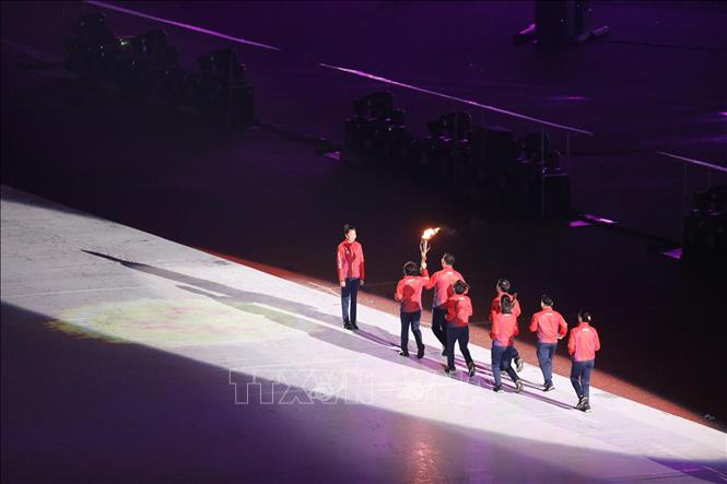 VĐV điền kinh Quách Thị Lan nhận ngọn lửa SEA Games 31 từ các VĐV. Ảnh: TTXVN
