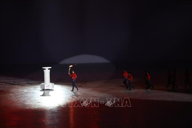 VĐV điền kinh Quách Thị Lan thắp lên ngọn lửa SEA Games 31. Ảnh: TTXVN
