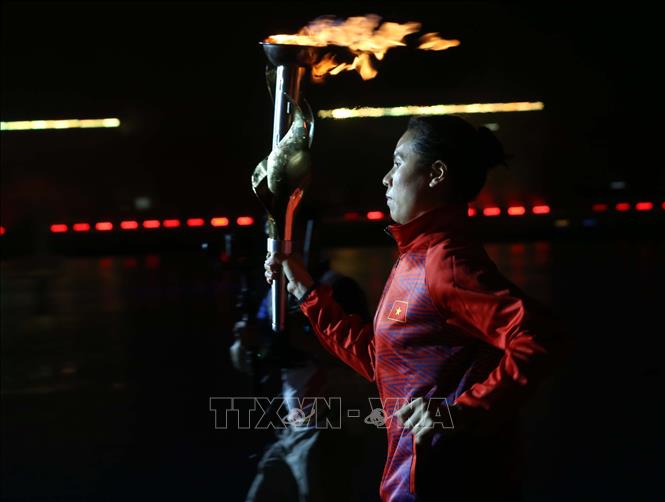 Cựu vô địch SEA Games Nguyễn Thị Tĩnh cầm đuốc từ phía ngoài SVĐ quốc gia Mỹ Đình chạy vào phía trong sân. Ảnh: TTXVN