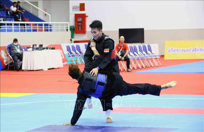  VĐV Vũ Văn Kiên (Việt Nam-đai đỏ) ghi điểm trước VĐV Muhammad Hazim Bin Mohamad Yusli của Singapore (đai xanh) ở hạng cân 55kg-60kg. Ảnh: Quang Quyết – TTXVN