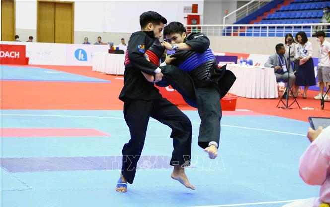 VĐV Ahmad Atif Irshad Bin Zahidi của Malaysia (đai đỏ) và VĐV Mark James Lacao của Philippines thi đấu ở hạng cân 60kg-65kg đối kháng nam. Ảnh: Quang Quyết – TTXVN