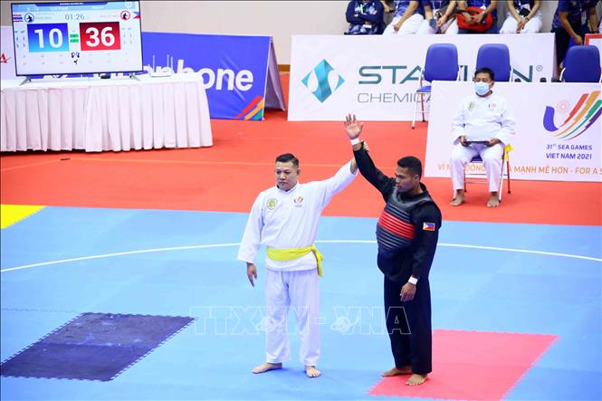 Trọng tài cho VĐV Alvin Campos (Philippines-đai đỏ) giành chiến thắng kỹ thuật sau khi VĐV Kuibrohem Kubaha (Thái Lan-đai xanh) gặp phải chấn thương không thể tiếp tục thi đấu. Ảnh: Quang Quyết – TTXVN