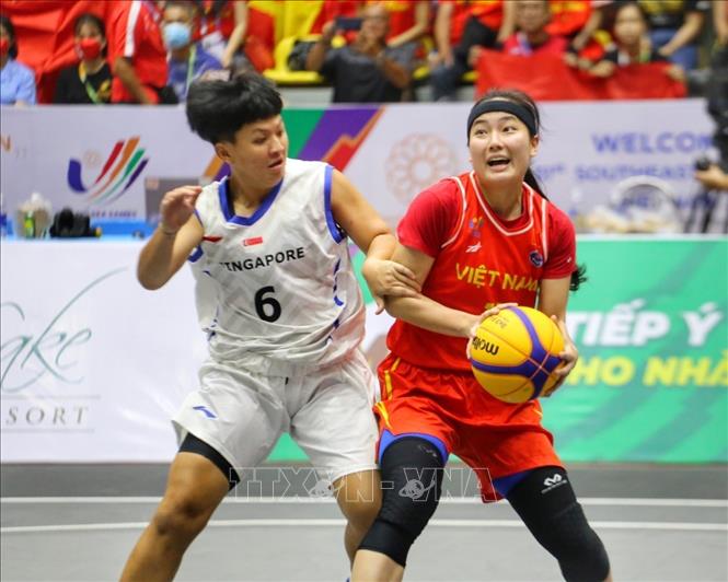 Pha lên bóng của Kayleigh Trương (số 11, nữ Việt Nam) trong sự truy cản của Jia Min Lim (số 6, nữ Singapore). Ảnh: Tuấn Đức - TTXVN