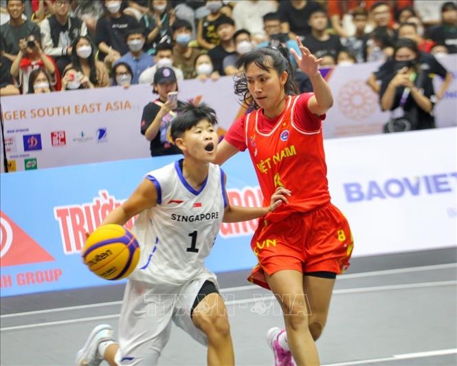 Pha cản phá của Huỳnh Ngoan (số 8, nữ Việt Nam) trước đợt lên bóng của Jiajia Chu (số 1, nữ Singapore). Ảnh: Tuấn Đức - TTXVN
