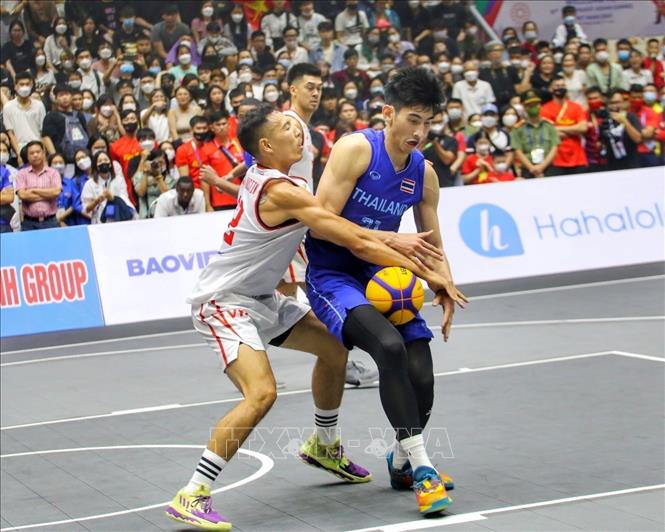 Pha cản phá của Justin Young (số 12, nam Việt Nam) trước pha tấn công của Chanatip Jakrawan (số 31, nam Thái Lan). Ảnh: Tuấn Đức - TTXVN