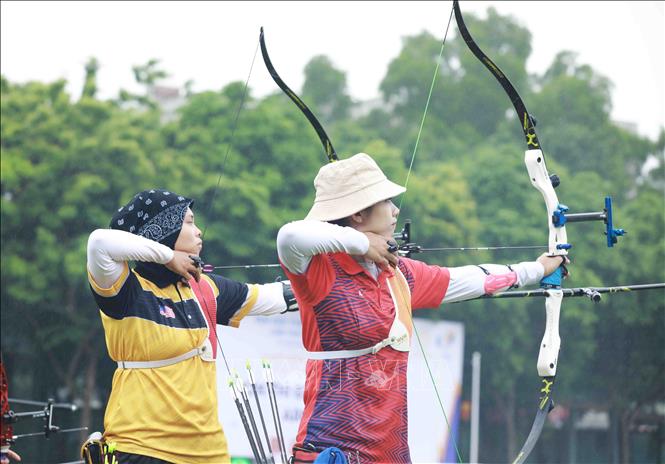 Female archers from Vietnam (in red) and Malaysia compete in the one-string bow event. VNA Photo: Vũ Sinh
