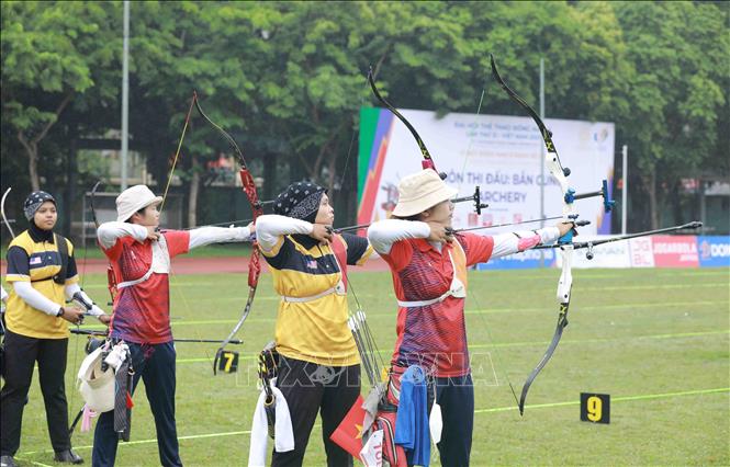 Female archers from Vietnam (in red) and Malaysia compete in the one-string bow event. VNA Photo: Vũ Sinh