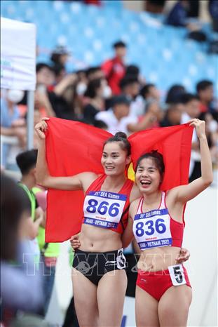 VĐV Nguyễn Thị Huyền (số áo 836) và VĐV Quách Thị Lan (số 836) hạnh phúc cùng nhau khi về đích giành chiến thắng. Ảnh: Quang Hà-TTXVN