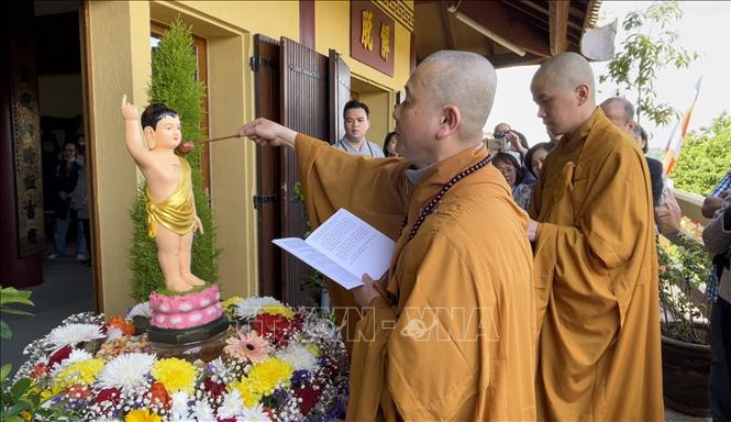 Thượng Tọa Thích Tâm Huy, Trụ trì Trúc Lâm Thiền viện thực hiện nghi lễ tắm Phật. Ảnh: Thu Hà - P/v TTXVN tại Pháp