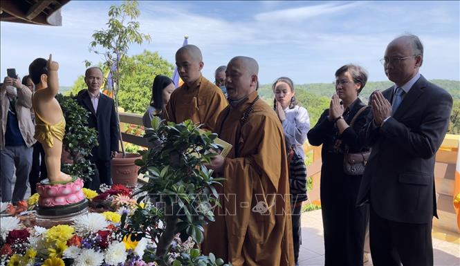 Thượng Tọa Thích Tâm Huy, Trụ trì Trúc Lâm Thiền viện thực hiện nghi lễ tắm Phật. Ảnh: Thu Hà - P/v TTXVN tại Pháp