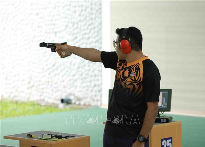 VĐV. Adzha Hafiz (Malaysia) thi đấu nội dung súng ngắn bắn nhanh nam 25m. Ảnh: Vũ Sinh - TTXVN