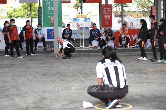 Trọng tài đo khoảng cách từ bi điểm đến vòng tròn trong trận thi đấu vòng loại bộ 3 kết hợp (2 nữ 1 nam) giữa đội Thái Lan (trái) và đội Malaysia (phải). Ảnh: Hoàng Hiếu - TTXVN 