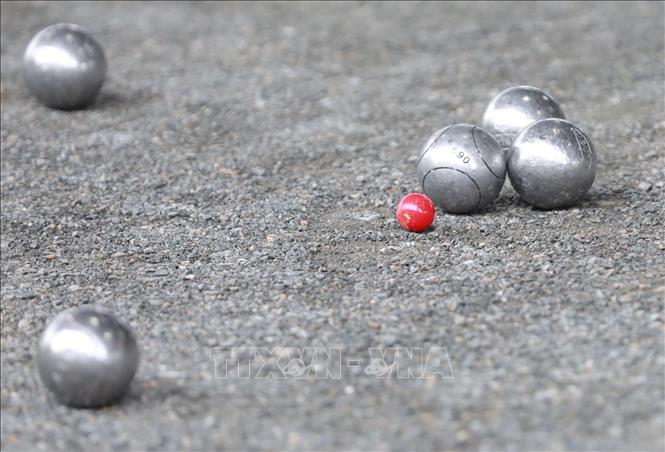 Trong ảnh: Bi sắt được tính 1 điểm khi gần bi điểm nhất, bi của đội gần viên bi điểm hơn đối phương cũng được điểm, đối phương không được điểm. Bi điểm (bi đích) màu xanh với bộ ba phối hợp 2 nữ, 1 nam hoặc màu đỏ với đôi nam nữ. Đội nào được tổng 13 điểm sẽ giành chiến thắng. Ảnh: Hoàng Hiếu - TTXVN